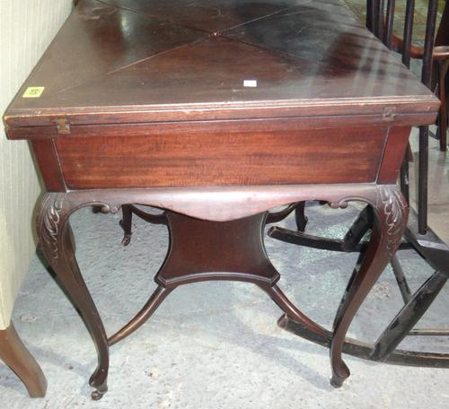 An Edwardian mahogany envelope card table on cabriole legs.