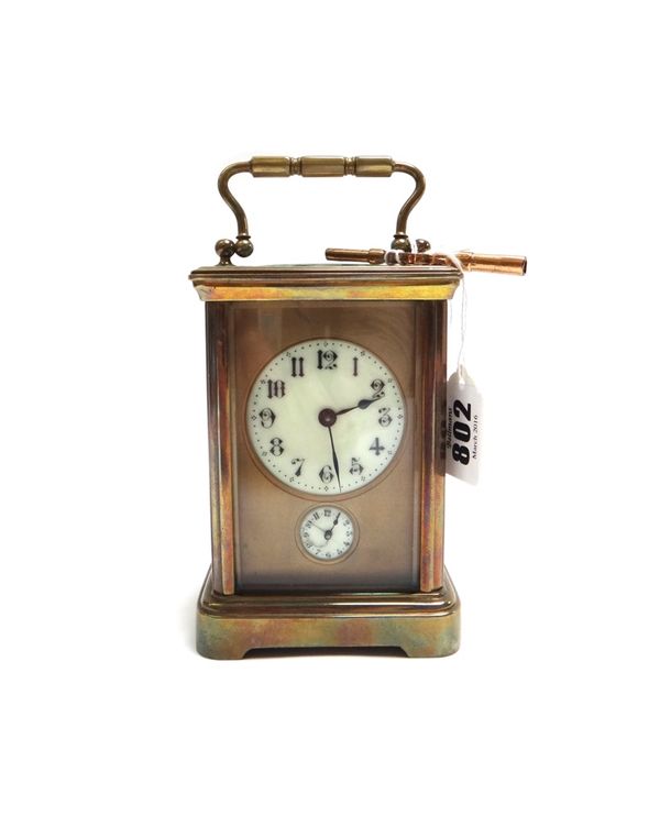 An Edwardian gilt brass cased carriage clock, with enamel dial and subsidiary alarm dial, on a plinth base, with single train movement, 13cm high. (ke