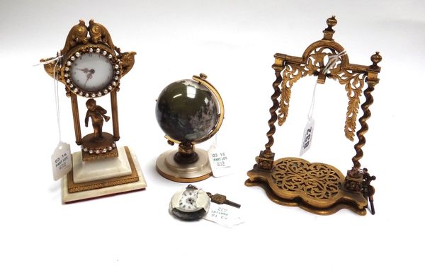 A Victorian brass pocket watch stand, the frame raised on spiral twist columns, 16cm high, a lady's silver cased fob watch, a desk clock with white en
