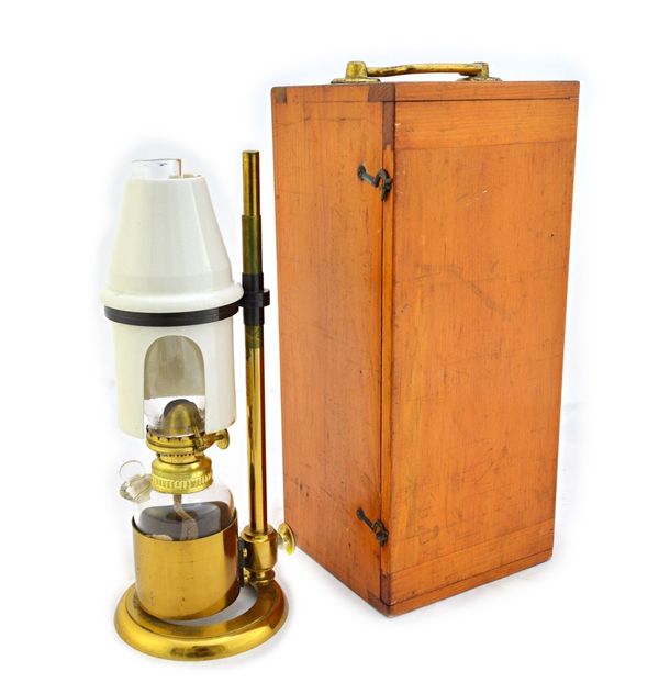 A brass microscope bench lamp, 19th century, by J. H. Steward, with height adjustable pottery shade and glass oil reservoir, the circular base detaile
