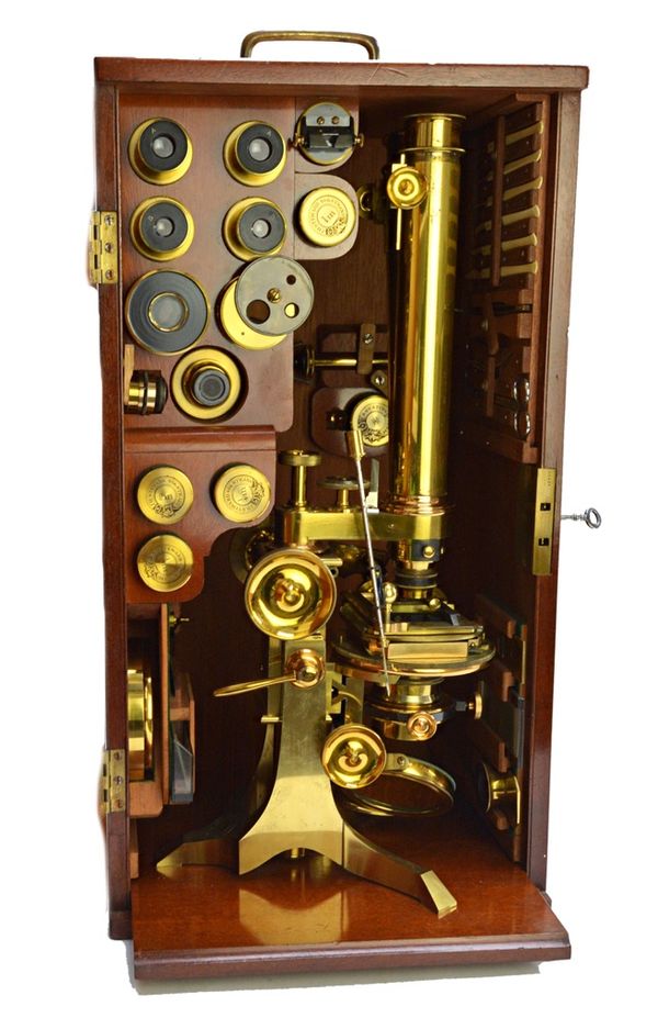 A lacquered brass binocular microscope by J. H. Steward, 19th century, with rack and pinion focusing and fine focus adjustment over a rotating stage,