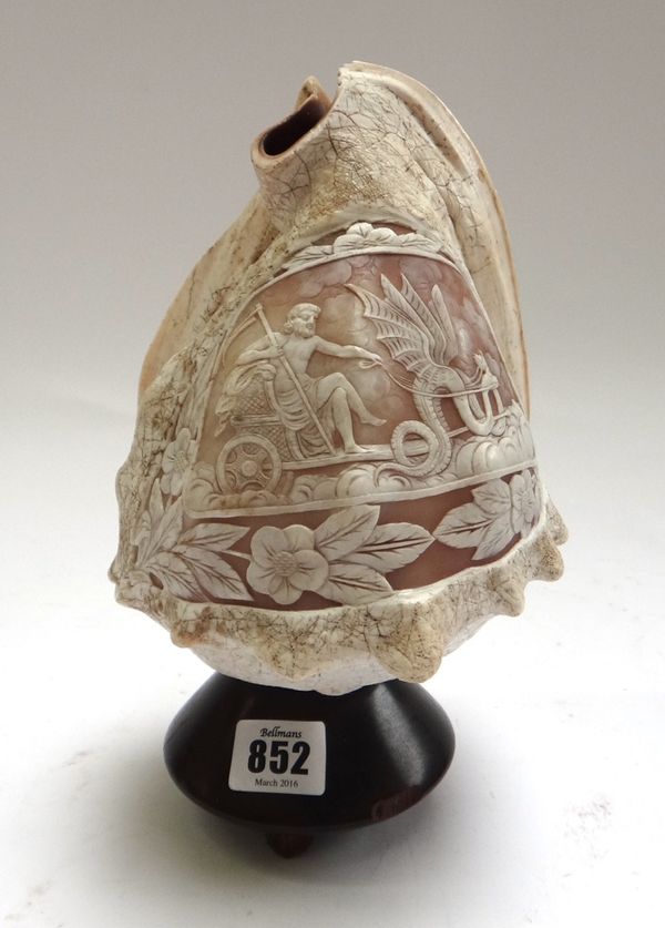 An Italian carved conch shell, late 19th century, depicting a bearded figure riding a chariot throne led by winged serpents, mounted as a lamp, the sh