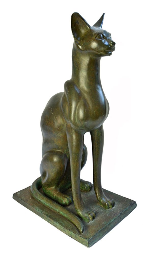 A bronze model of an Egyptian cat, 20th century, with alert ears and curled tail, signed 'Marcel', on an integral plinth base, 69cm high.  Illustrated