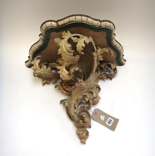 A pair of Italian pale grey painted wooden wall brackets of rococo style, late 19th century, with shaped foliate painted gilt heightened shelves, 55cm
