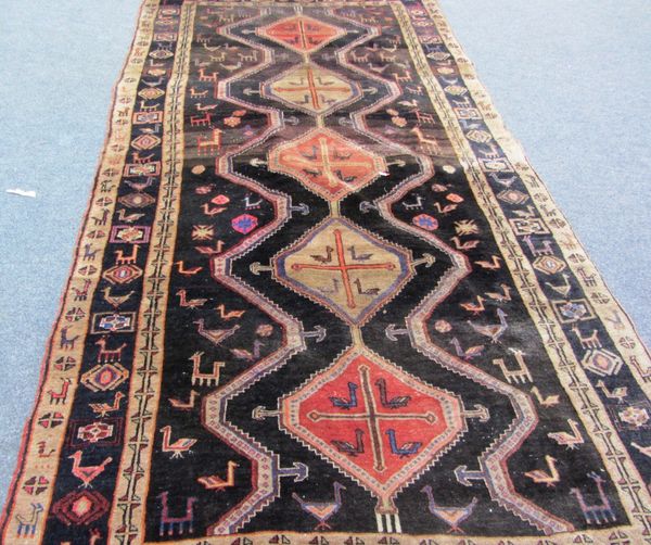 A Bidjar Kelleh, Persian, the black field with five diamonds supporting animals, birds and flowerheads, with a complementary border, 315cm x 157cm.  I