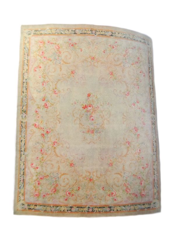 A large Savonnerie carpet, cream main field with central rose floral spray within similar scrolling spandrels, approximately 565cm x 449cm.  Illustrat