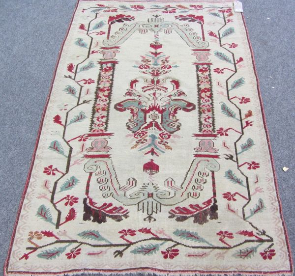 An Anatolian rug, the ivory field with a central elongated medallion, brackets to each end, pillars to side, trailing leaf vine surround, 161cm x 105c