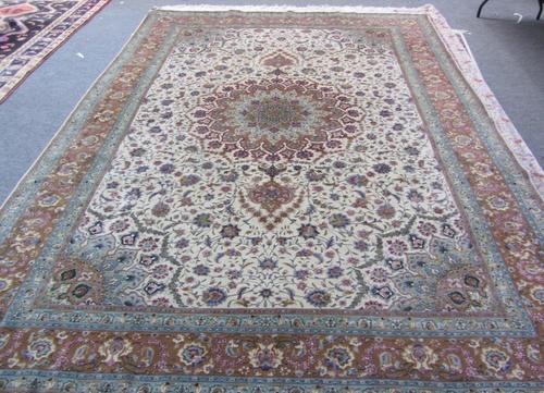 A part silk Tabriz carpet, Persian, the beige field with a rosette pole medallion, matching spandrels, all with delicate floral sprays, a brown palmet