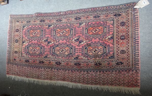 A Saryk Chuval, Turkmen, the madder field with two rows of three guls, supporting guls, a sunburst border, 74cm x 148cm.