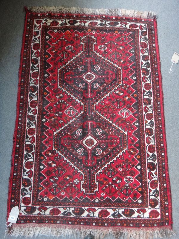 A Shiraz rug, South Persian, the madder field with a double medallion, minor motifs, an ivory border, 160cm x 107cm, together with a Shiraz rug, the w