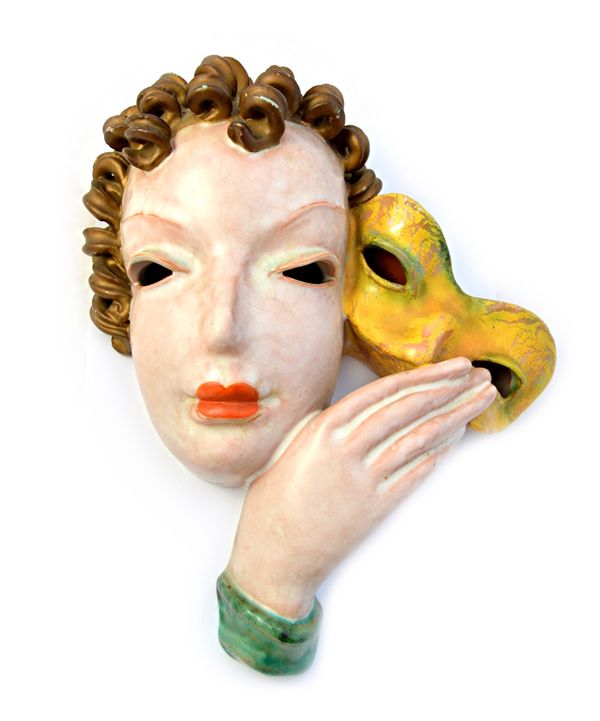 A Goldscheider pottery wall mask, 1930's, depicting an Art Deco female bust holding a yellow mask, indistinctly marked, 28cm high.  Illustrated