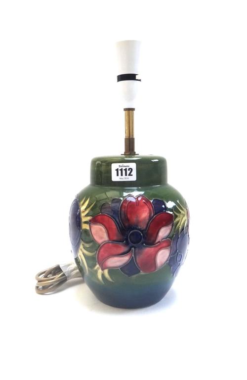 A Moorcroft pottery green ground table lamp decorated with a wide band of anemone, impressed mark to base, 20cm high.