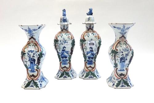 A garniture of Dutch Delft vases and covers, late 19th century, of baluster form, each decorated with Oriental figures, and a matching pair of vases,