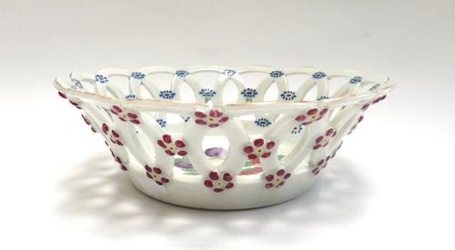A Worcester porcelain pierced circular basket, circa 1765, attributed to the workshop of James Giles, the exterior moulded with puce florets with yell
