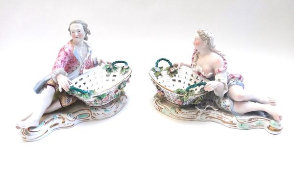 A pair of Meissen style porcelain figural sweetmeat dishes, late 19th century, each modelled as gallant and companion with a foliate and pierced two h