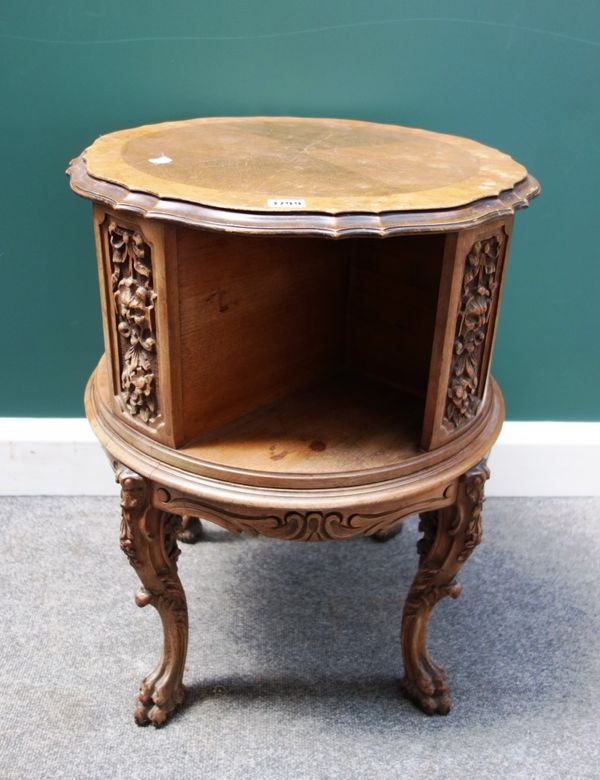 An early 20th century carved walnut circular revolving book stand on four cabriole supports, 50cm wide.