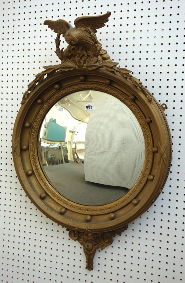 A Regency style gilt framed convex wall mirror with eagle crest, 62cm wide x 100cm high.