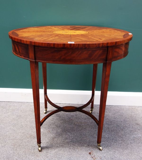 An Edwardian tulipwood banded mahogany inlaid occasional table, the oval top centred with patera, on four tapering square supports, united by 'X' fram