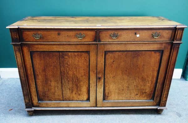 A George III oak dresser base, with a pair of drawers over cupboards, on stile feet, 137cm wide.