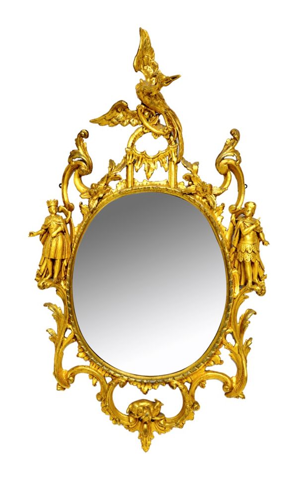 An early George III giltwood oval mirror, in the manner of Thomas Johnson, the oval plate within re-gilded carved foliage and floral frame, surmounted