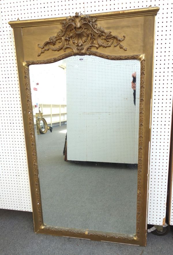 A late 19th century gilt framed wall mirror with shell and scroll crest over bevelled arch top mirror plate, 100cm wide x 172cm high.