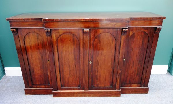 A mid 19th century rosewood breakfront side cabinet, the four arch top panel doors, on plinth base, 153cm wide.