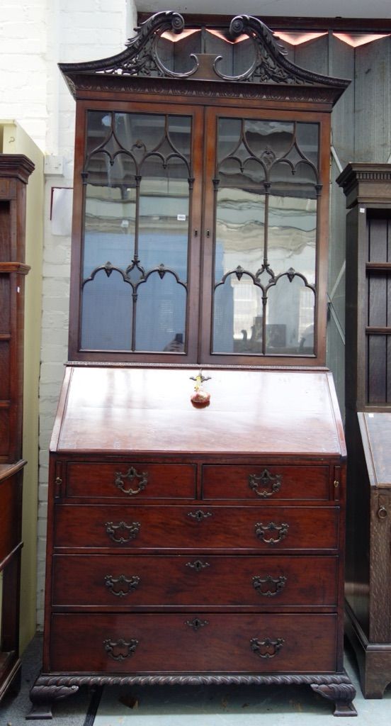 A 19th century mahogany bureau bookcase, the pierced and carved broken swan neck cornice over a pair of astragal glazed doors, the fall enclosing a fi