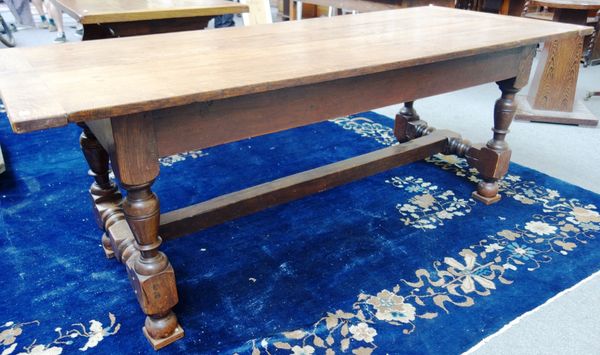 A 17th century style oak refectory table, the cleated plank top on turned supports, united by stretcher, 82cm wide x 201cm long.