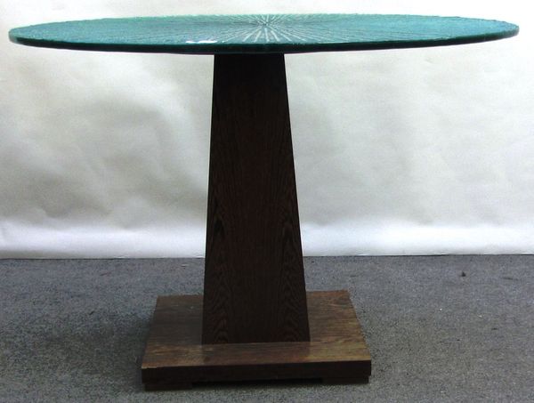 A 20th century centre table, the rippled glass circular top on a square tapering palm wood base, 111cm wide.