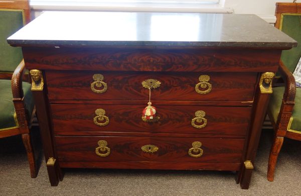 An early 19th century French commode, the black marble top over a gilt metal mounted mahogany base of four long graduated drawers, flanked by caryatid