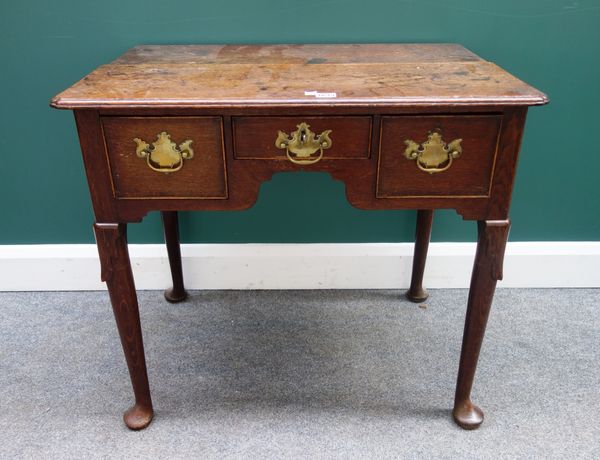 A mid 18th century oak lowboy, with thee frieze drawers on club supports, 77cm wide.