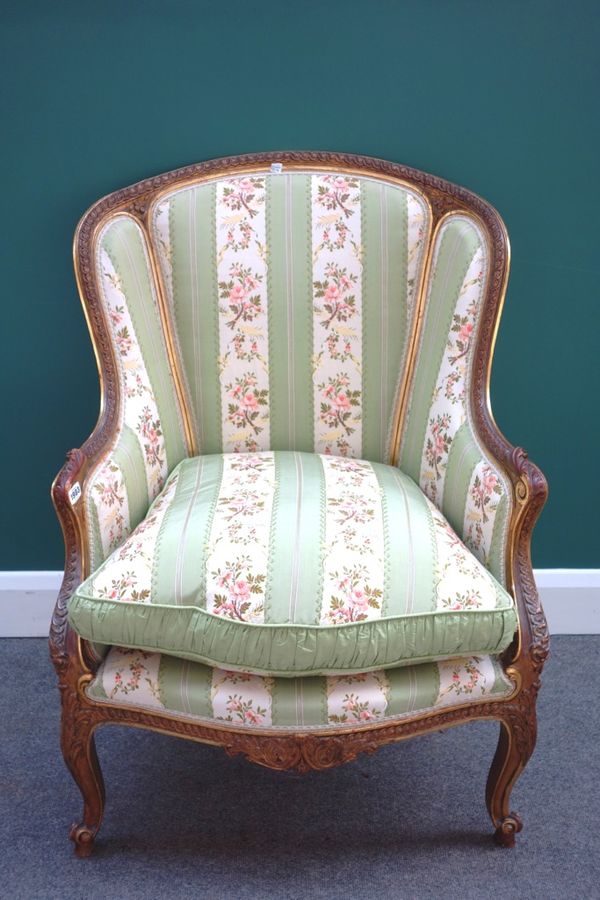 A Louis XV style tub back armchair, with serpentine seat on scroll supports.