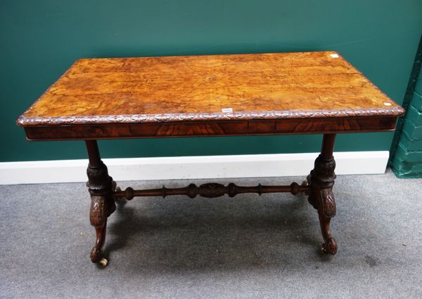 A Victorian figured walnut centre table, the rectangular top with carved floral edge, on a pair of turned columns and four downswept supports, 122cm w