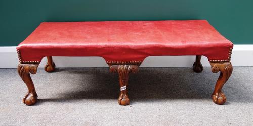 An early 20th century walnut framed rectangular stool of 18th century style, on six cabriole supports, on ball and claw feet, 101cm wide.