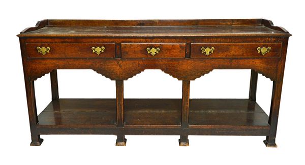 An 18th century oak dresser base, with three drawers above the shaped frieze, on six canted block supports, united by pot board undertier, 167cm wide.