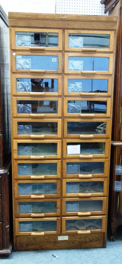 Dudley & Co Limited Showcase Manufacturer's, a mid 20th century oak framed haberdashery cabinet, with two rows of glass fronted drawers, on plinth bas