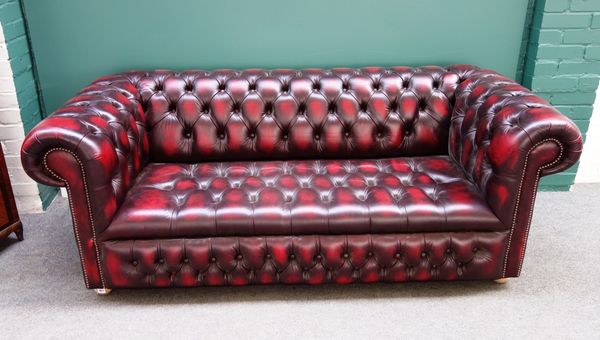 A 20th century red leather button upholstered Chesterfield sofa, with studded decoration, 198cm wide.