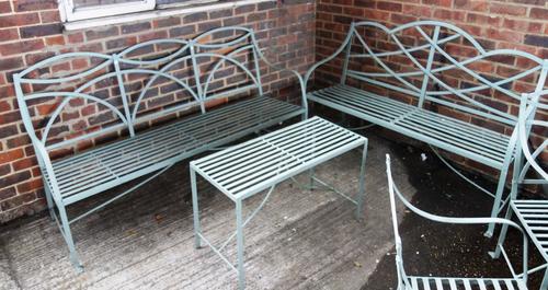 A Regency design grey painted garden suite to comprise, two benches, 180cm wide and 154cm wide and a rectangular side table, 92cm wide, (3).