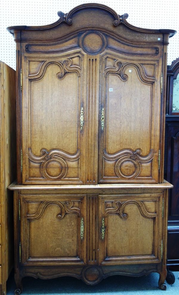 A 19th century French oak buffet deux corps, the arch cornice over a pair of shaped panel doors, on scroll feet, 147cm wide x 250cm high.