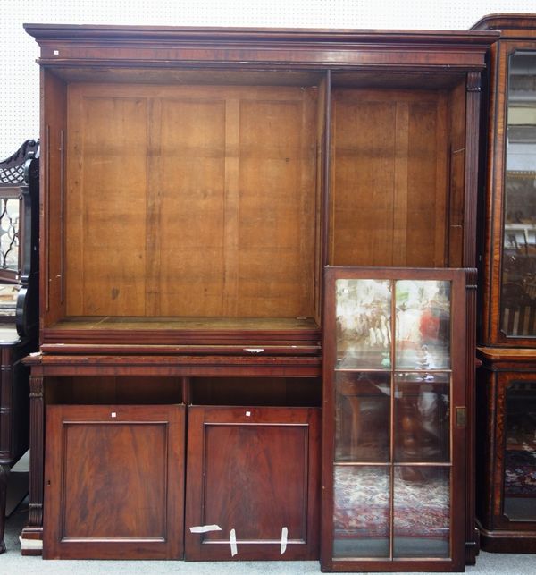 A mid 19th century mahogany bookcase cupboard, with three glazed doors over three panel cupboards, on plinth base, 225cm wide x 250cm high.