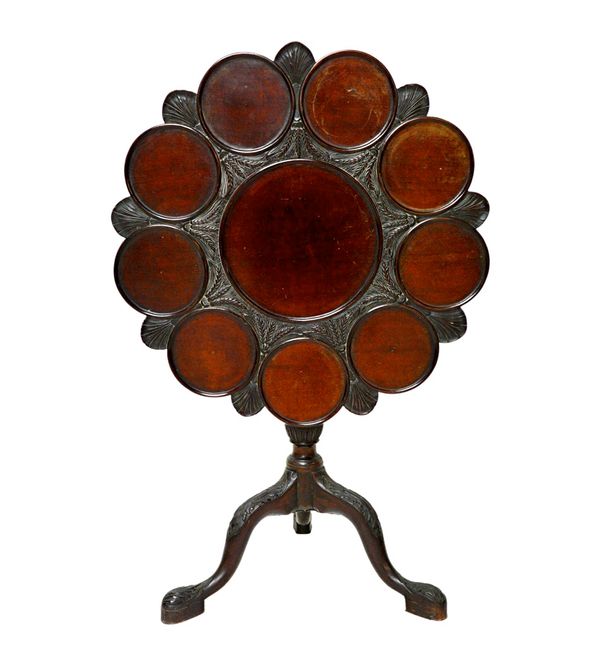 After John Channon, an 18th century style carved mahogany supper table, the shaped snap top with ten recessed wells, on bird cage support and carved t