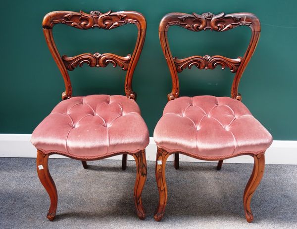 A set of six Victorian rosewood framed dining chairs, each with floral carved crest and waist rail, over serpentine seat and cabriole supports, (6).