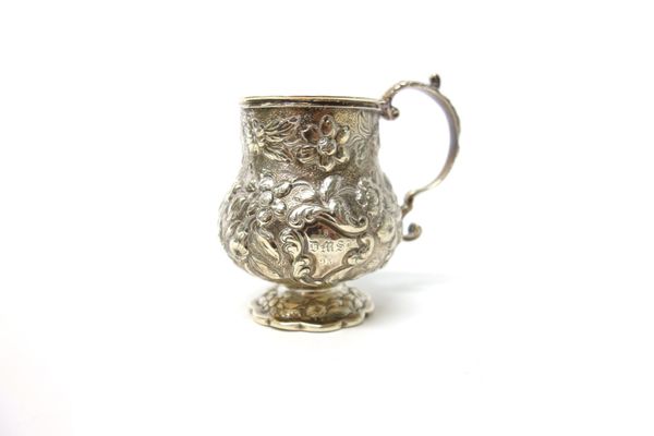 A George IV silver christening mug, of baluster form, with a scrolling handle, the body profusely embossed with floral and foliate decoration and on a