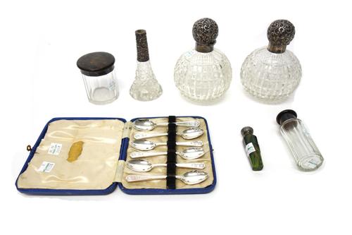 A pair of Victorian silver topped globular faceted glass scent bottles, the hinged tops embossed with floral scroll work and having ground glass stopp