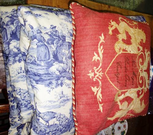 A blue and white bed spread depicting classical scenes 100 inches x 125 inches together with a lion and unicorn motif cushion.