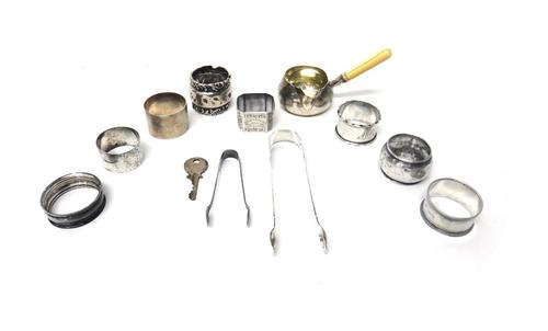 A Victorian silver brandy saucepan, with a turned ivory handle, London 1875, together with eight various silver napkin rings, two pairs of silver suga