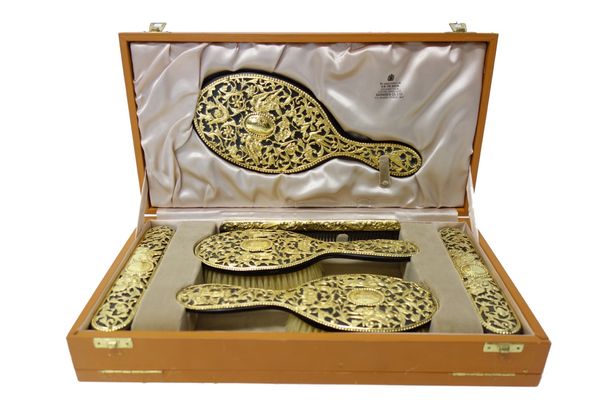 A six piece silver gilt mounted lady's dressing table set, comprising; a hand mirror, two hairbrushes, two clothes brushes and a comb, the Victorian m