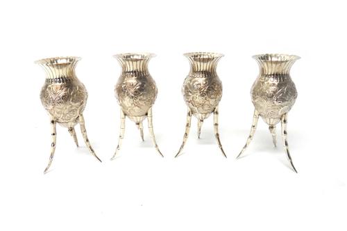 A set of four Oriental vases, the bodies of each decorated with chrysanthemums beneath a fluted flared rim and raised on three curved bamboo legs, pos