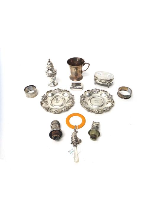 Silver, comprising; a rectangular snuff box, Birmingham 1901, a rattle formed as Mr Punch, Birmingham 1921, with a mother of pearl handle, an oval tri