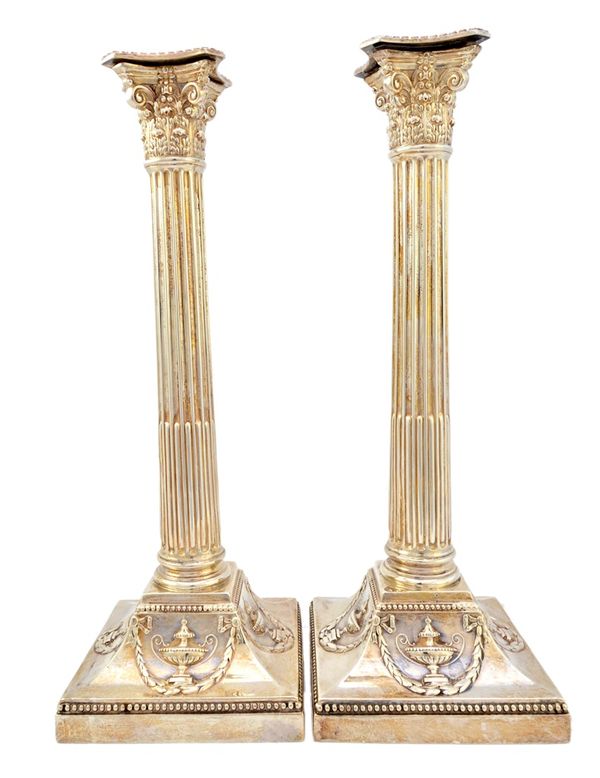 A pair of late Victorian silver table candlesticks, each formed as a Corinthian column on a beaded square base, height 33.5cm, Birmingham 1896. Illust